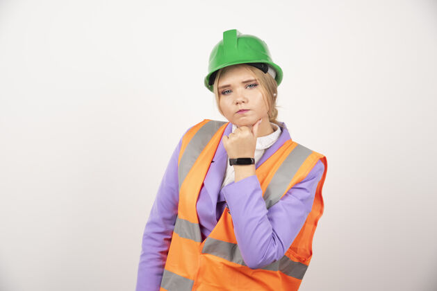 女性白墙上戴着头盔的女建筑工人工人头盔女士
