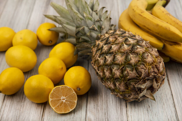 菠萝顶视图美味的水果 如菠萝香蕉和柠檬隔离在一个灰色的木制表面食物膳食配料