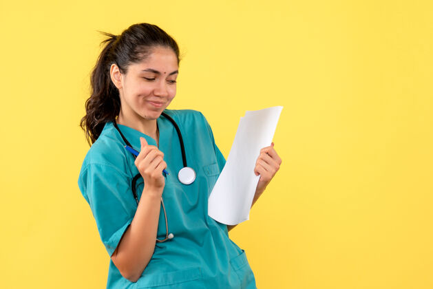 听诊器正面图满意的女医生拿着黄色背景的文件满意背景抱