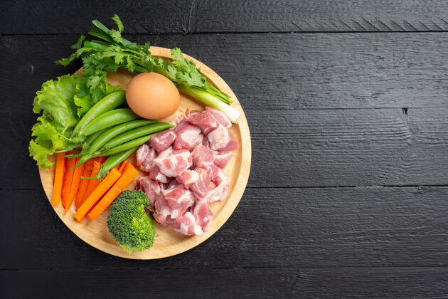 花椰菜健康新鲜的宠物食品配料在黑暗的表面猪肉肉鸡蛋