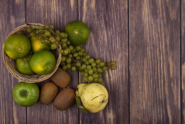 食物顶视图临摹空间梨与猕猴桃 橘子 苹果和葡萄在一个篮子里的木制墙壁橘子水果木头