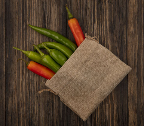一餐彩色和新鲜的辣椒在木表面麻布袋俯视图营养美味新鲜