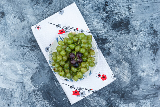 叶子顶视图绿色葡萄在板上的肮脏石膏和厨房毛巾背景水平大夏天葡萄