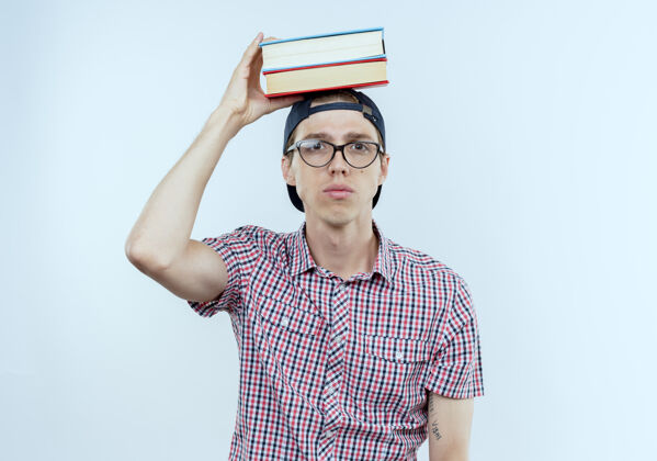 戴戴着眼镜和帽子把书戴在头上的年轻学生男孩帽子眼镜男人