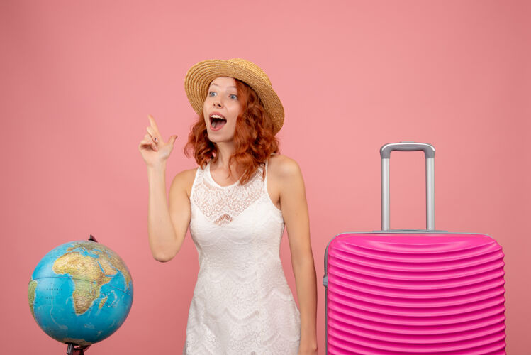 前面年轻女性游客的正面图 粉红色的墙上挂着粉红色的包夏天时尚可爱