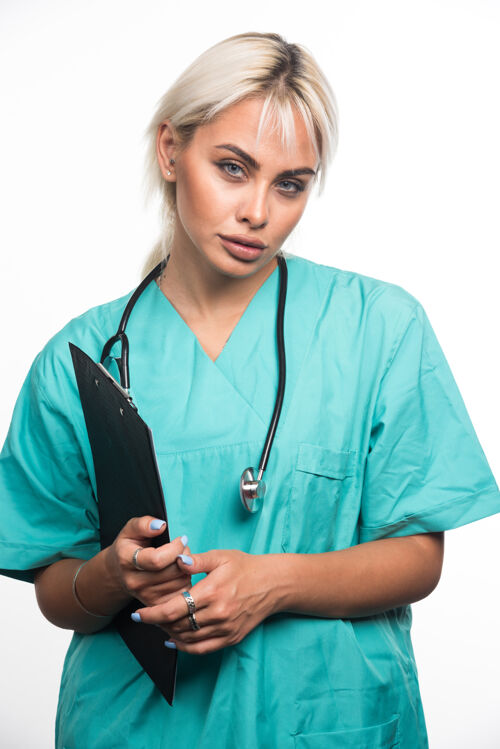 制服女医生拿着剪贴板在白色的表面护理站着女性