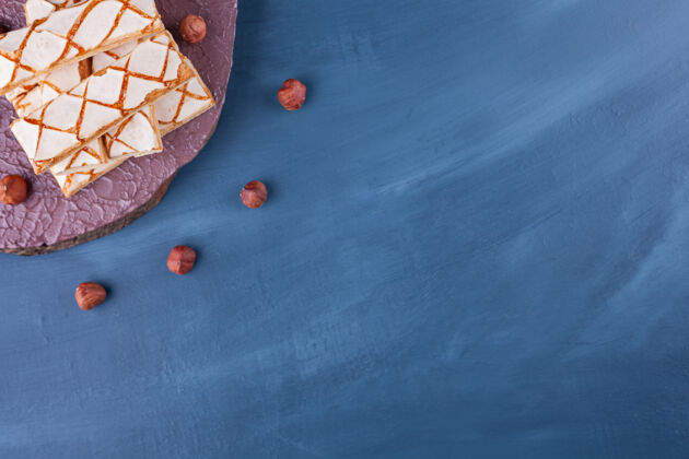 风味把榛子撒在蓝色的华夫饼干上卡路里小吃华夫饼