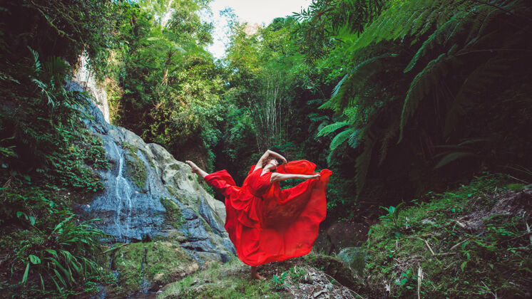 自然穿红裙子的女孩在瀑布里跳舞芭蕾舞魅力瀑布