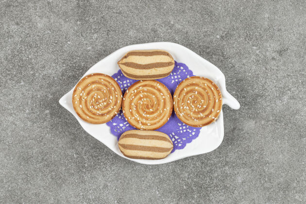 美食美味的巧克力条纹饼干和芝麻饼干放在白色盘子里脆面包房零食