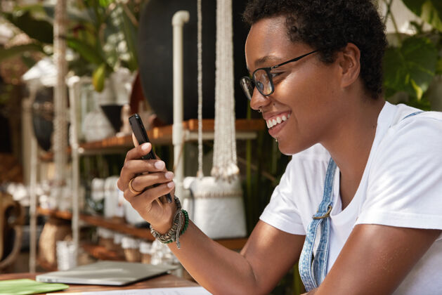 通信积极的黑皮肤女人兴奋的好消息得到通知智能手机满意无线人类