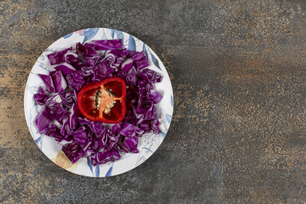盘子胡椒粉切碎在切碎的红色卷心菜盘中 放在大理石表面风味生的健康