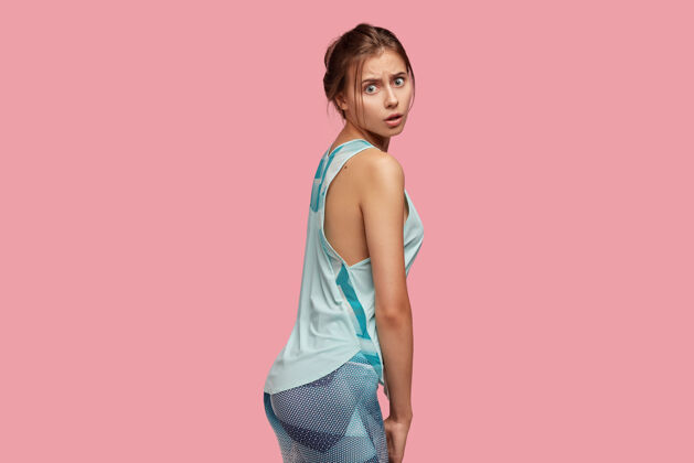 健身房情绪激动的女运动员展示健康的臀部和臀部 侧身站立运动装侧面饮食