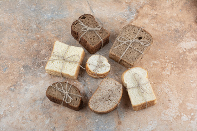 面包房各种各样的面包用绳子绑在大理石背景上绳索切片吐司