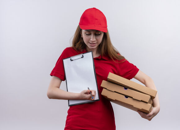 女人身穿红色制服的年轻送货女孩手里拿着包裹和笔 剪贴板俯视着与世隔绝的白色墙壁上的复印空间送货按住钢笔