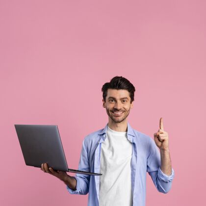 手势笑脸男拿着笔记本电脑指着上的正面图肖像人男性