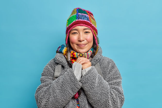 温暖可爱的爱斯基摩女性 面颊红润 双手合十 微笑着 穿着时尚保暖的帽子和冬衣 生活在北极或北极肖像节日微笑