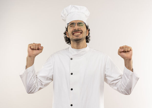 穿着年轻的男厨师闭着眼睛 身着厨师制服 戴着眼镜 在白色的墙壁上做着“是”的手势欢乐厨师年轻