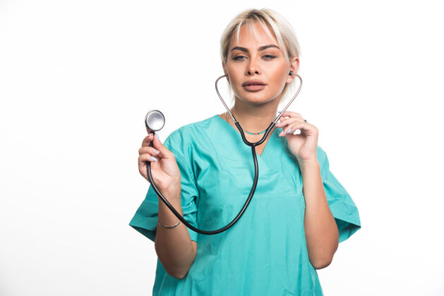 人类女医生在白色表面使用听诊器站着制服成人
