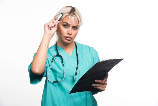 站着女医生拿着剪贴板在白色的表面思考着什么医院文件护理