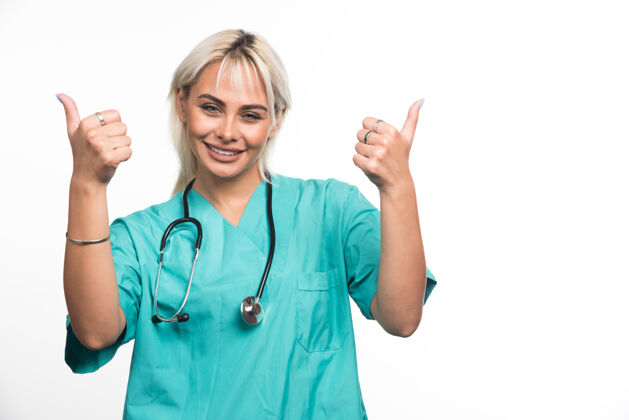 听诊器女医生用听诊器在白色表面竖起大拇指成人医生工作