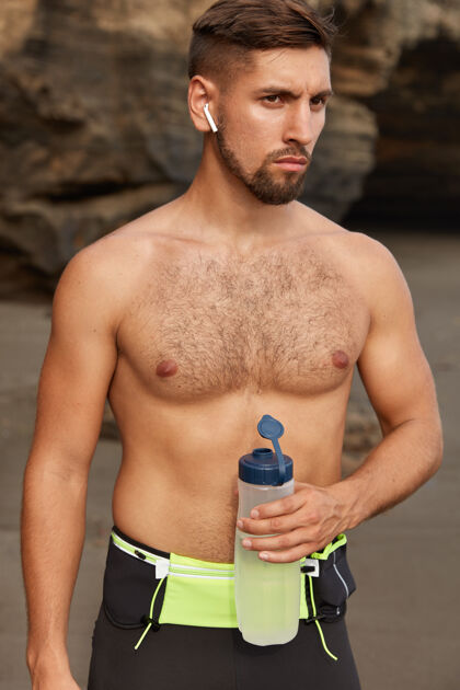 未刮胡子自信的男性运动爱好者户外拍摄 在海岸线有晨练健身悬崖裸体
