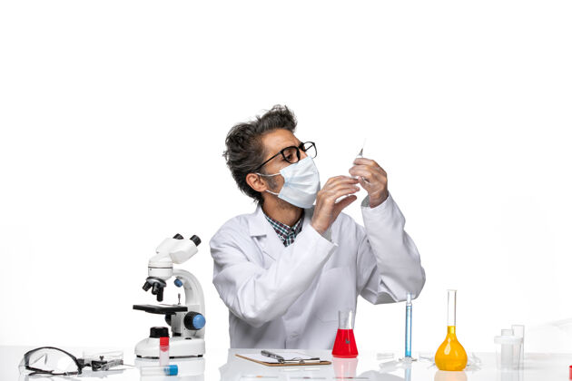 技师正面图身着白色医疗服的中年科学家在准备注射科学注射医学