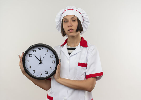 女性自信的年轻女厨师 身着厨师制服 手拿时钟 在白色的复制空间里显得孤立无援持有空间制服