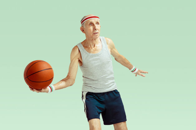 男子穿运动服的老人在草地上打篮球团队篮球训练