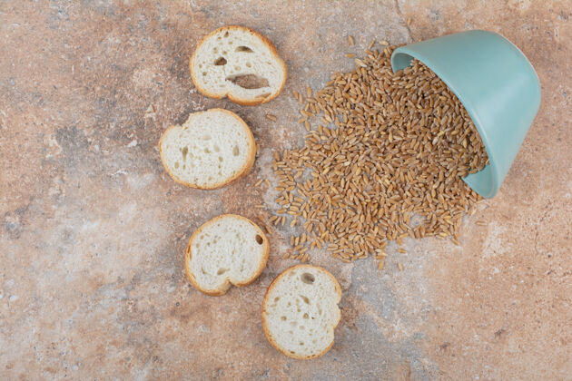 谷类用面包片把大麦粒从碗里放在大理石表面上食物面包谷物
