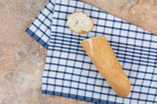 切片新鲜的法式面包片放在条纹桌布上面包皮美味新鲜