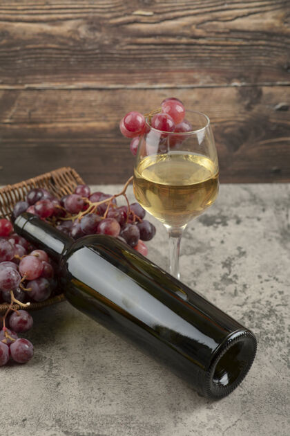 酒精大理石桌上放着一篮红葡萄和一杯白葡萄酒收获水果新鲜
