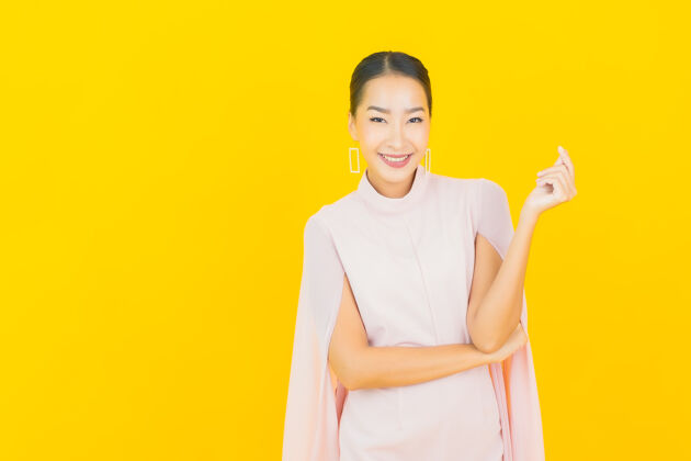 护理画像美丽的亚洲年轻女子微笑着在黄色的墙上有许多动作成人漂亮女性