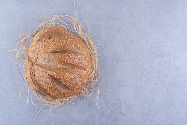 酵母一个面包放在大理石表面的稻草堆上正餐面包面包屑