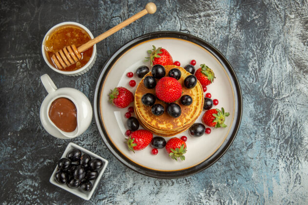 营养品俯瞰美味的薄煎饼与蜂蜜和水果在光表面蛋糕甜水果清淡水果食物