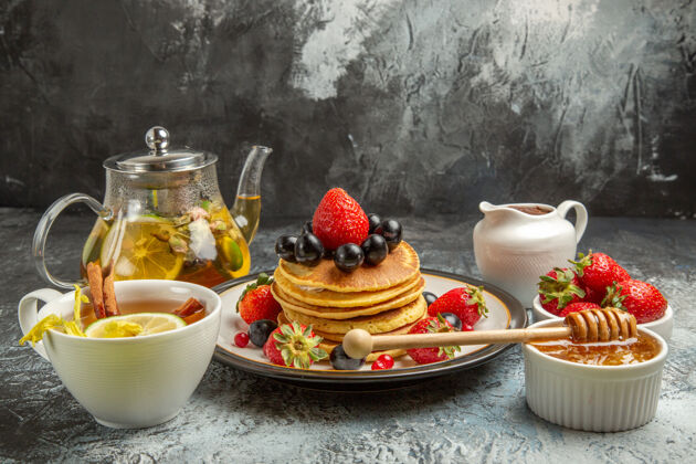 用餐正面图：美味的薄饼配水果和茶 清淡的水果早餐托盘灯正面