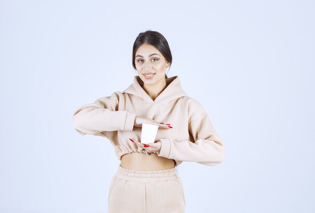 成人一个穿着粉色睡衣的年轻女人手里拿着一杯饮料姿势茶人