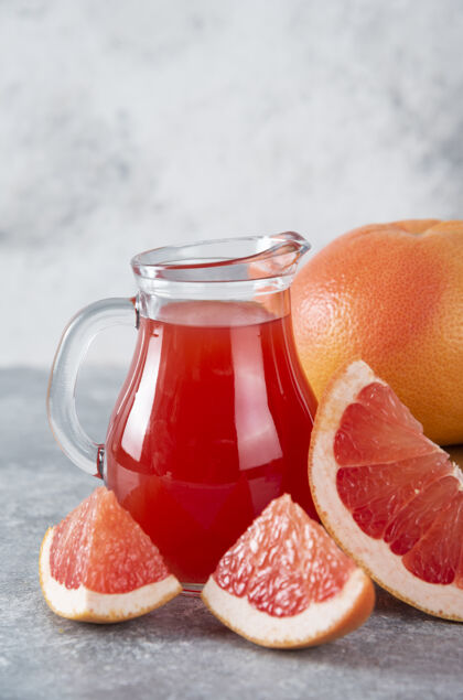 酸一大罐新鲜葡萄柚汁和水果片五颜六色柑橘餐桌