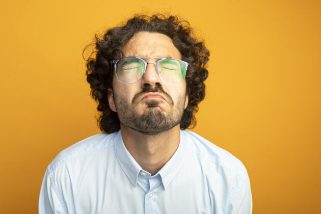 年轻年轻英俊的白人男子戴着橙色背景隔离眼镜的特写镜头戴男人橙色