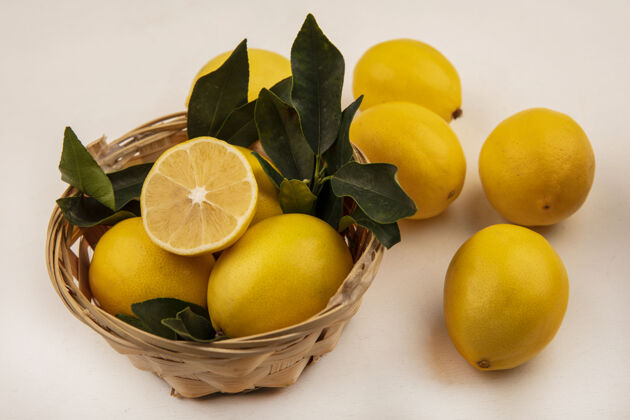 柑橘白色墙上桶上黄色和圆形柠檬的俯视图块配料新鲜