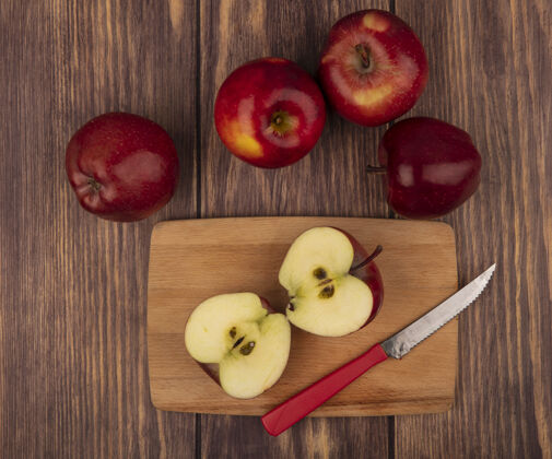 中心顶视图健康的红苹果在一个木制的厨房板与刀与苹果隔离在木墙上苹果厨房板