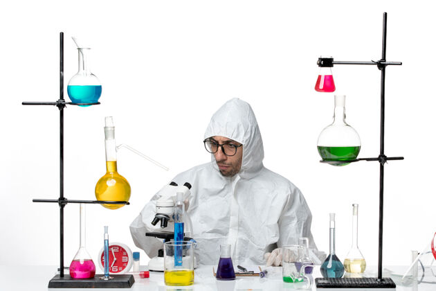 容器正面图穿着特殊防护服的男科学家坐着实验室办公桌实验