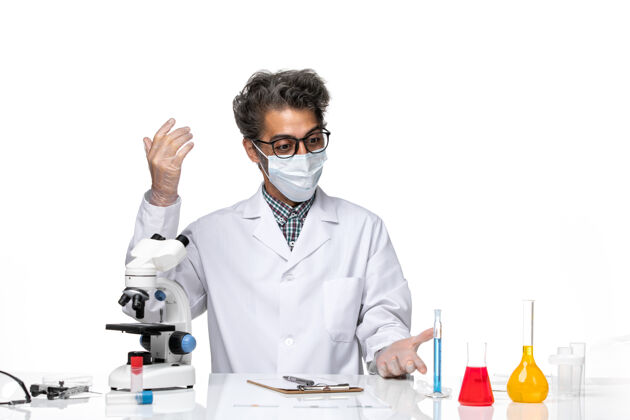 化学正面图身着特殊套装的中年科学家坐着写笔记笔记实验科学