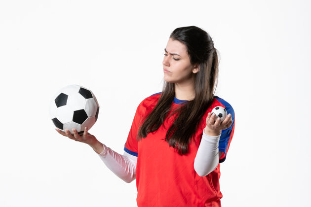 体育前视图穿着运动服的年轻女性 白色墙壁上有足球白人前面人