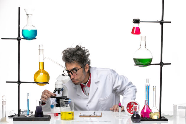 实验室穿着医学服的中年科学家使用显微镜的正视图化学人成人