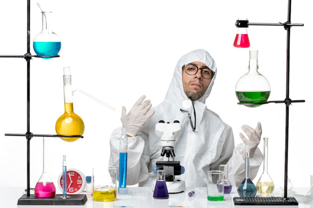 特殊正面图穿着特殊防护服的男科学家围坐在桌子旁 拿着解决方案化学桌子保护