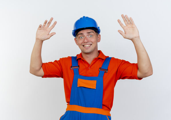 男性高兴的年轻男子建设者身穿制服 戴着安全帽举起手来建筑工人手制服