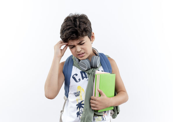背小男孩戴着书包 戴着耳机 抱着书 手放在头上 眼睛闭着 脸上一片白手势关心包
