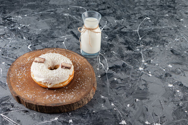 甜点美味的椰子甜甜圈配巧克力和牛奶放在大理石桌上霜冰烘焙