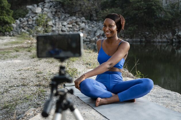 女性非裔美国瑜伽老师在户外练习电话女人身体平衡