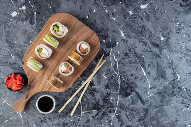 海鲜大理石桌上各种寿司卷的木制切割板餐晚餐什锦